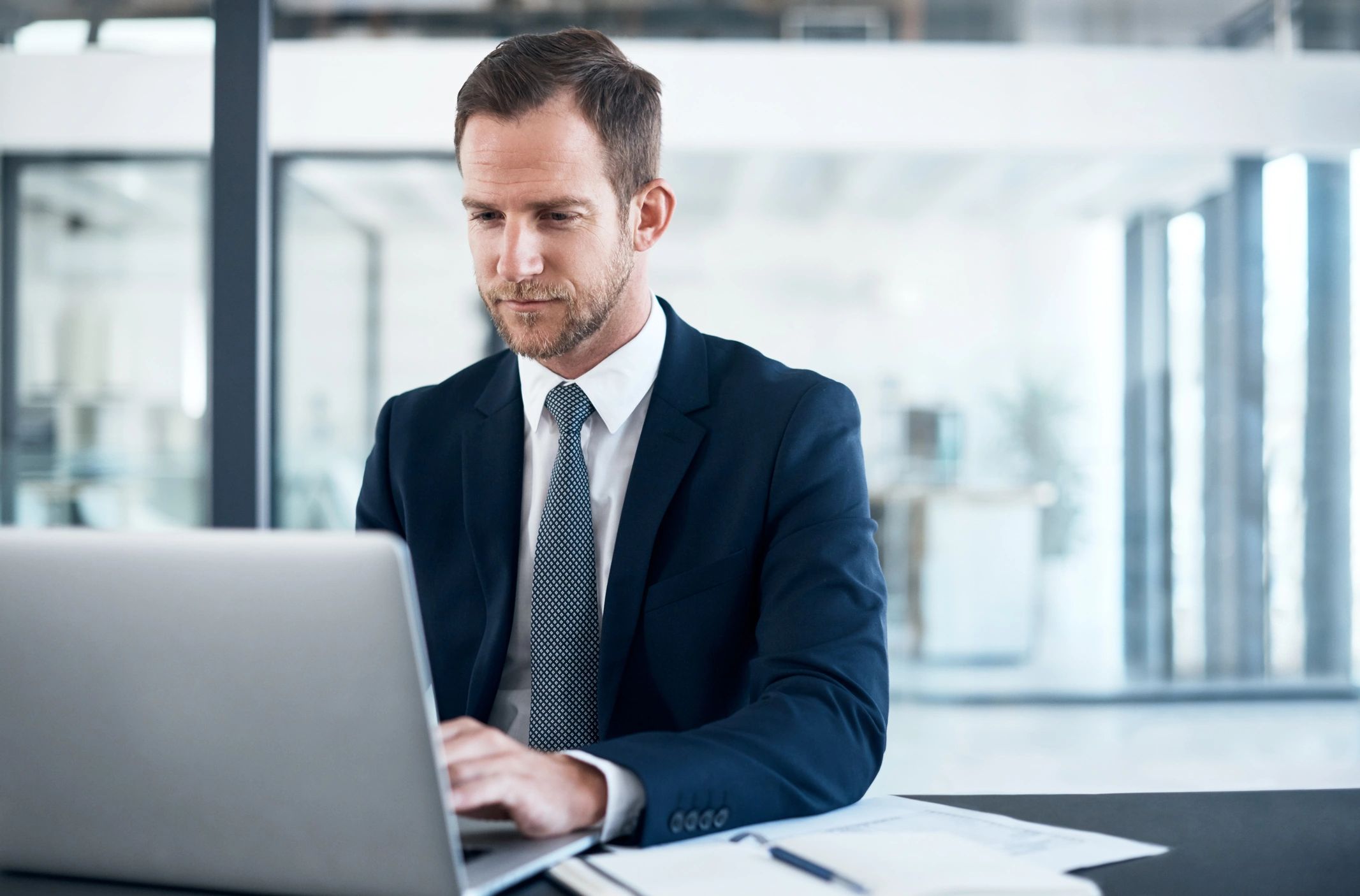 Consultant travaillant sur un ordinateur portable, concentré sur la gouvernance et la conformité.